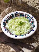 Cucumber salad with parsley on a stone wall