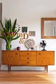 Letter-shaped ornaments, bouquet and fan on 50s retro sideboard