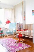 Bright nursery with cot, pale blue cantilever chair and red rocking moose