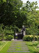 Front garden path of stone flags interspersed with lawn and Victorian-style front gate