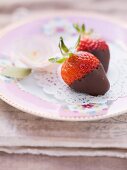 Chocolate strawberries on a pink, floral-patterned plate