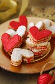 Heart-shaped Christmas biscuits with red icing and icing sugar