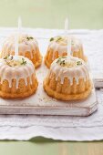 Mini Bundt cakes decorated with thyme, icing and candles
