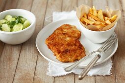 Putenschnitzel mit Pommes frites und Gurkensalat