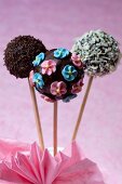 Chocolate cake pops decorated with sugar flowers and light and dark chocolate sprinkles