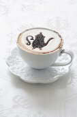 A cappuccino with a pattern stencilled in cocoa powder