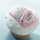A cupcake decorated with a marzipan book