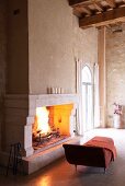 Chaise-longue in front of open fireplace in Château Maignaut (Pyrenees, France)