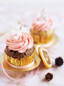Weihnachtliche Schoko-Cupcakes mit rosa Buttercreme und Schneeflocken verziert