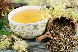 A bowl of meadowsweet tea and tea leaves in a tea strainer