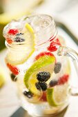 Blackberries, Blueberries, Raspberries, Lemon and Lime in Mason Jar with Soda and Ice