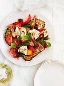 Tomato salad with ham, peaches & mozzarella on bruschetta