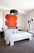 Schlafzimmer mit dunkelgrauem Velourteppichboden und poppigem orangem Posterbild über dem Bett