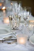 Festively set table with various glasses and tealight holders