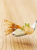 A prawn with cress foam on a spoon