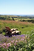 Rattan sun loungers in meadow with view across French landscape