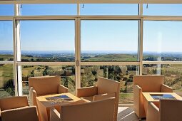 Elegante Sesseln und Beistelltisch vor Fensterfront mit Panoramablick
