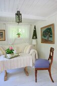 Simple, white living room with vintage furniture and large oil painting with wooden frame