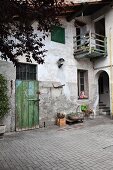 Old, rustic farmhouse with stone-paved courtyard