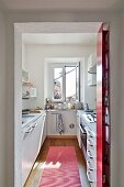 View of modern galley kitchen through open doorway