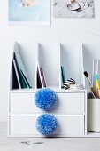 Pompoms decorating drawers of desk filing trays