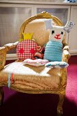 Imaginative, hand-sewn soft toys on old upholstered armchair