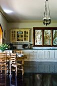 Country style: dining area on a high gloss, dark wooden flooring and kitchen counter with white, lower cabinets