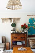 View across coffee table to rustic cupboard and disused wooden rake on wall