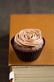 A chocolate cupcake with a rose made of icing