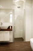 White, modern designer bathroom with separate shower area and brown tiled floor