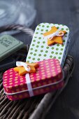 Small, polka-dotted metal tins decorated with star-shaped buttons and ribbons