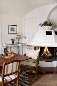 Traditional dining area with wicker armchair in front of open fire