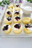 Little, fluted cut-out sponge cakes with bilberry jam