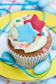 Vanille-Cupcake mit bunten Sternen, Zuckerkonfetti und blauen Zuckermandeln