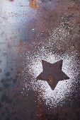 The outline of a star in icing sugar