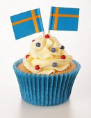 A cupcake decorated with buttercream and Swedish flags