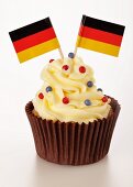 A cupcake decorated with buttercream and German flags