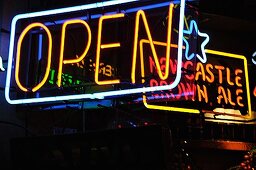 Neon signs outside a pub in the evening