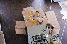 View from above of free-standing kitchen island and dining table with breakfast place settings