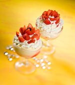 An ice cream sundae with vanilla ice cream, whipped cream and strawberries