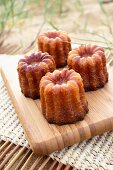 Four cannelés on a chopping board