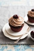 Cherry cupcakes topped with chocolate cream
