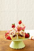 Strawberry Shortcake Cupcakes on a Pedestal Dish; One Halved