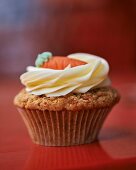 A carrot cupcake topped with cream cheese icing