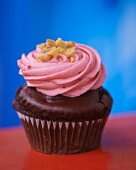 A chocolate cupcake topped with pink icing