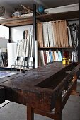 Alte Werkbank vor Regalen mit Holzelementen in Loft-Werkstatt