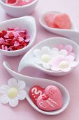 Sugar hearts and flowers made from edible paper in bowls