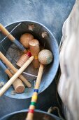 Croquet mallets and equipment in metal bucket