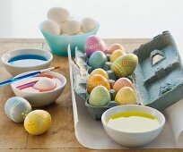 Decorated eggs next to bowls of dye