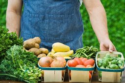 Bauer zeigt Gemüse in Spankörben